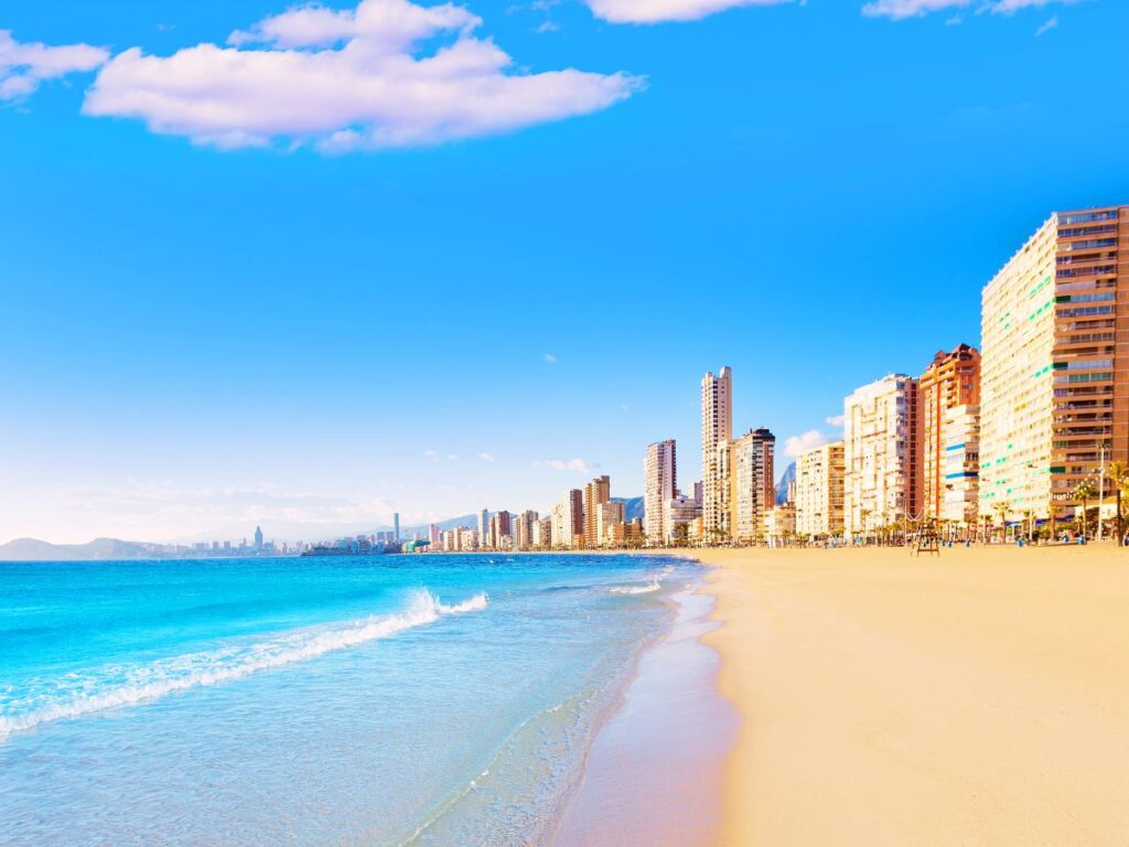 Walking on the beach, peaceful sunrise, sun sand, sea and hotels on the beach, Alicante, Spain